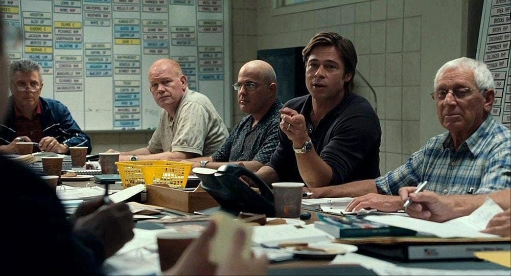 Scene from Moneyball showing Billy Beane with his scouting team.